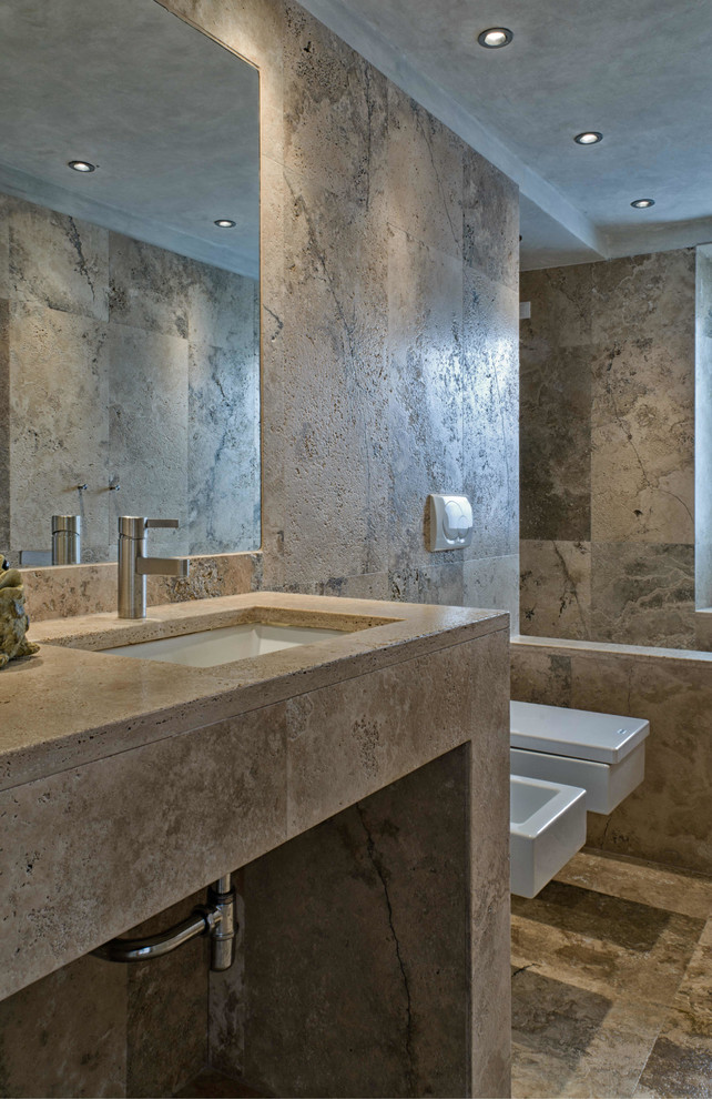 На фото: главная ванная комната в стиле модернизм с угловой ванной, каменной плиткой, бежевыми стенами, полом из травертина и накладной раковиной