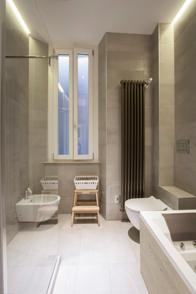 Exempel på ett mellanstort modernt beige beige en-suite badrum, med beige skåp, en jacuzzi, en kantlös dusch, en vägghängd toalettstol, grå kakel, porslinskakel, grå väggar, klinkergolv i porslin, ett fristående handfat, bänkskiva i kalksten, grått golv och med dusch som är öppen