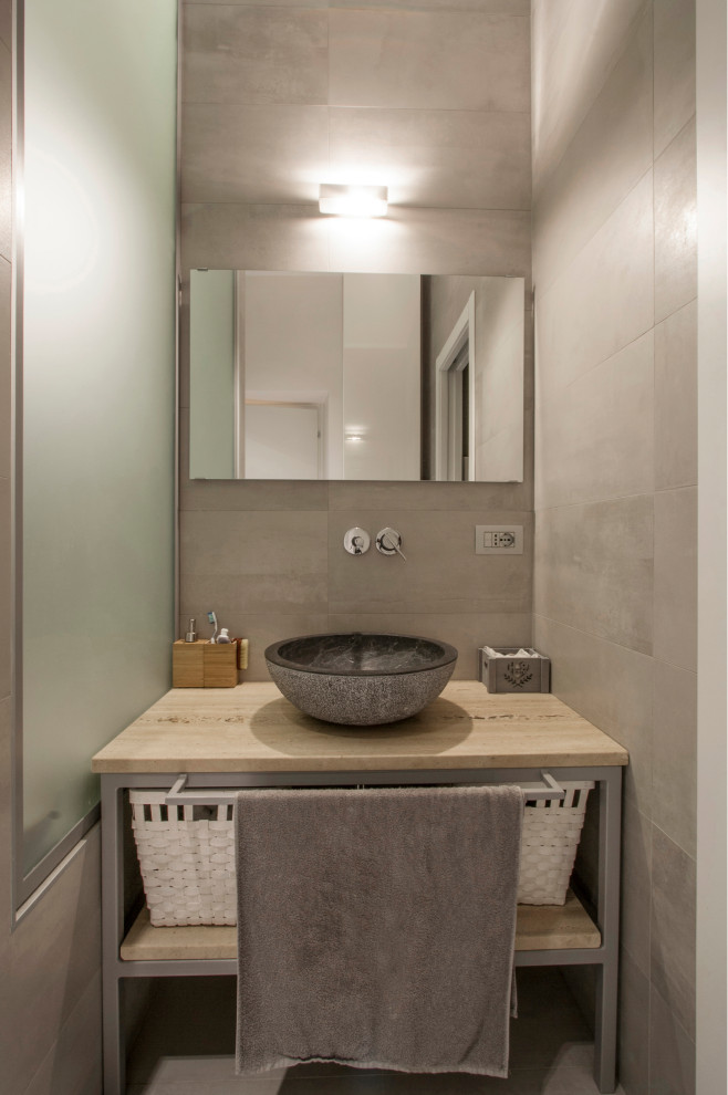 Пример оригинального дизайна: главная ванная комната среднего размера со стиральной машиной в современном стиле с открытыми фасадами, бежевыми фасадами, гидромассажной ванной, душем без бортиков, инсталляцией, серой плиткой, керамогранитной плиткой, серыми стенами, полом из керамогранита, настольной раковиной, столешницей из известняка, серым полом, открытым душем, бежевой столешницей, тумбой под одну раковину, напольной тумбой и многоуровневым потолком