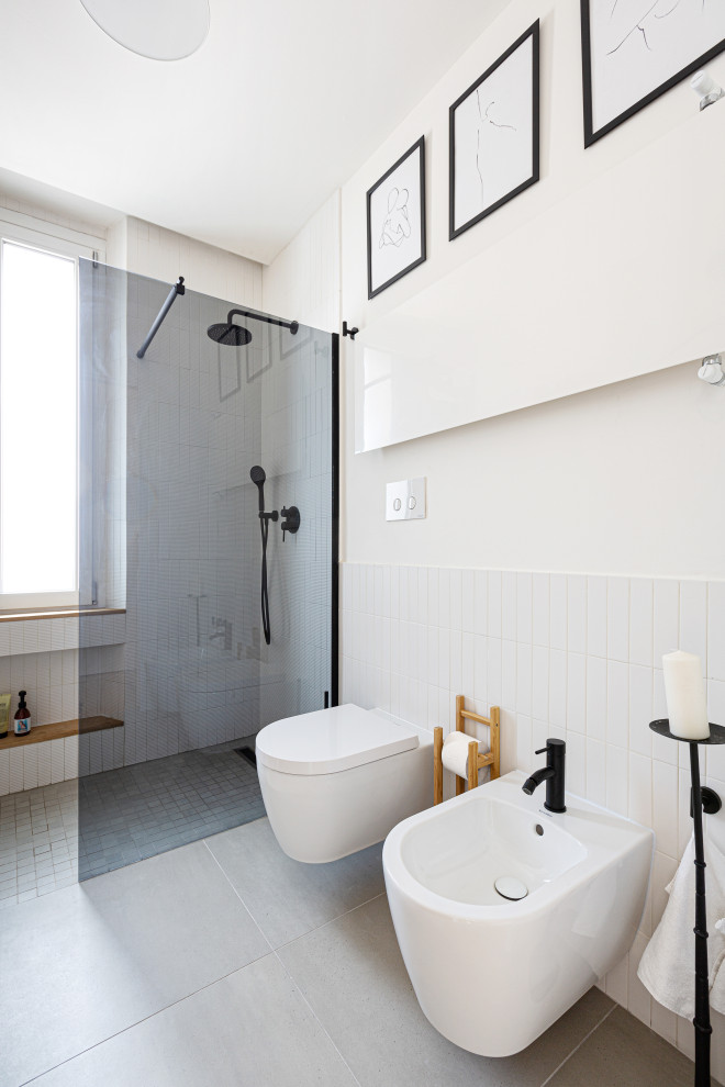 Foto på ett litet skandinaviskt badrum med dusch, med släta luckor, skåp i ljust trä, en kantlös dusch, en vägghängd toalettstol, vit kakel, stickkakel, vita väggar, betonggolv, ett fristående handfat, träbänkskiva, grått golv och med dusch som är öppen