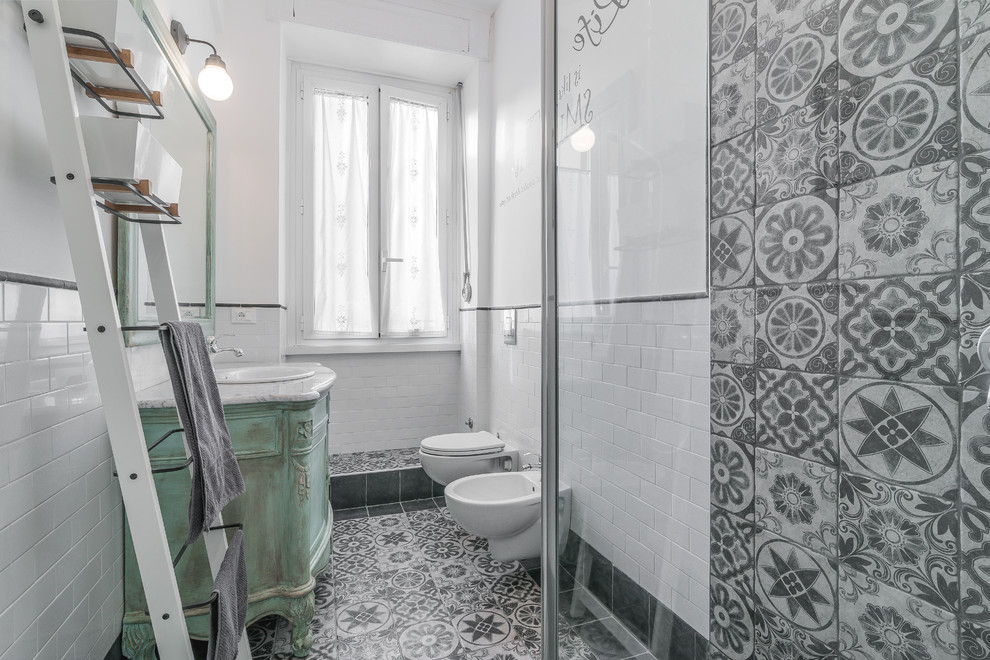 Inredning av ett shabby chic-inspirerat mellanstort badrum, med skåp i slitet trä, en vägghängd toalettstol, keramikplattor, vita väggar, klinkergolv i keramik, ett nedsänkt handfat, marmorbänkskiva och luckor med infälld panel