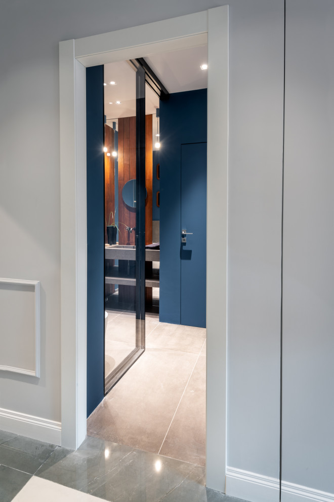 Источник вдохновения для домашнего уюта: ванная комната среднего размера со стиральной машиной в современном стиле с открытыми фасадами, серыми фасадами, душем в нише, инсталляцией, бежевой плиткой, керамогранитной плиткой, синими стенами, полом из керамогранита, душевой кабиной, монолитной раковиной, столешницей из плитки, серым полом, душем с распашными дверями, белой столешницей, тумбой под одну раковину, подвесной тумбой, многоуровневым потолком и деревянными стенами
