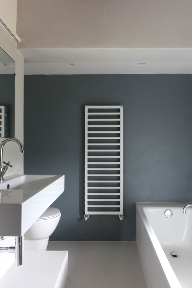 Foto di una piccola stanza da bagno design con vasca da incasso, WC monopezzo e pareti grigie