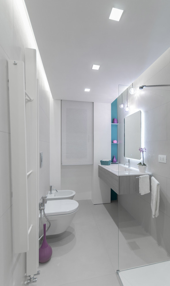 Inredning av ett modernt litet badrum med dusch, med en hörndusch, vita väggar, släta luckor, grå skåp, en bidé, grå kakel, ett integrerad handfat, grått golv och med dusch som är öppen
