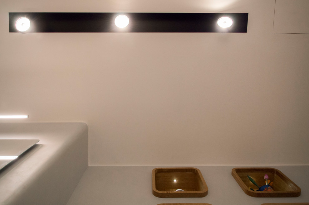 Foto på ett mellanstort funkis grå badrum med dusch, med en dubbeldusch, en vägghängd toalettstol, grå kakel, porslinskakel, grå väggar, klinkergolv i porslin, ett fristående handfat, bänkskiva i akrylsten, grått golv och med dusch som är öppen