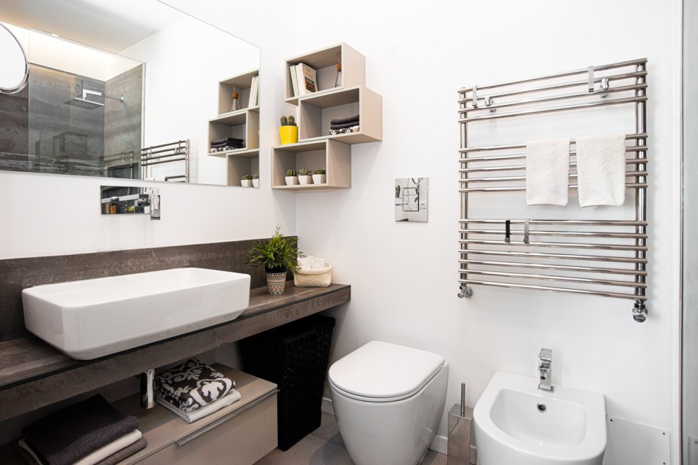 Immagine di una stanza da bagno design con lavabo a bacinella, top piastrellato e top grigio