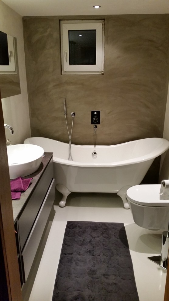 Example of a mid-sized trendy master freestanding bathtub design in Other with furniture-like cabinets, a wall-mount toilet, multicolored walls and a vessel sink
