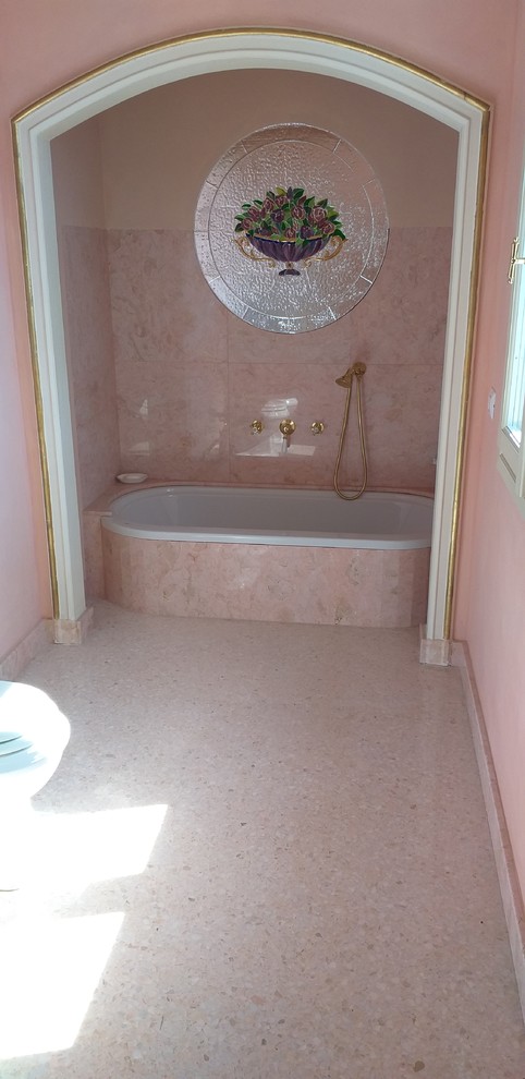 Inredning av ett klassiskt stort badrum, med ett platsbyggt badkar, en toalettstol med separat cisternkåpa, rosa kakel, marmorkakel, rosa väggar, ett piedestal handfat och rosa golv