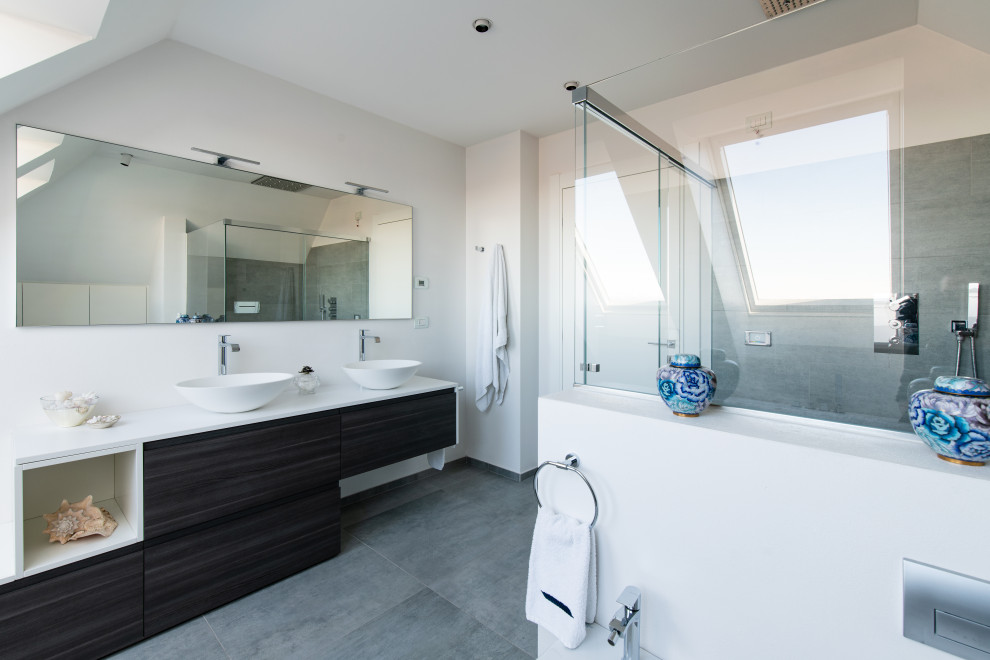 Foto på ett mellanstort funkis vit en-suite badrum, med grå skåp, en jacuzzi, en kantlös dusch, en vägghängd toalettstol, grå väggar, klinkergolv i keramik, ett fristående handfat, grått golv och dusch med skjutdörr