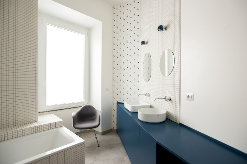 Inspiration för ett stort funkis blå blått en-suite badrum, med släta luckor, blå skåp, ett platsbyggt badkar, en dusch/badkar-kombination, en toalettstol med separat cisternkåpa, vit kakel, mosaik, vita väggar, klinkergolv i keramik, ett fristående handfat, träbänkskiva och beiget golv