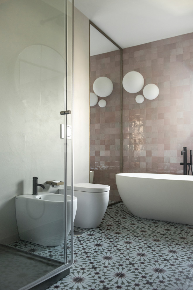 Пример оригинального дизайна: большая главная ванная комната в современном стиле с отдельно стоящей ванной, раздельным унитазом, розовой плиткой, плиткой мозаикой, серыми стенами, полом из цементной плитки, накладной раковиной, столешницей из искусственного камня, зеленым полом, душем с раздвижными дверями, душем над ванной, плоскими фасадами, темными деревянными фасадами и розовой столешницей