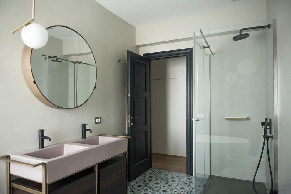 Идея дизайна: большая главная ванная комната в современном стиле с плоскими фасадами, отдельно стоящей ванной, душем над ванной, раздельным унитазом, розовой плиткой, плиткой мозаикой, серыми стенами, полом из цементной плитки, накладной раковиной, зеленым полом, душем с раздвижными дверями, темными деревянными фасадами, столешницей из искусственного камня и розовой столешницей