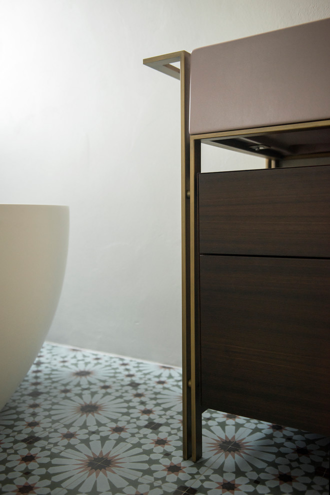 На фото: большая главная ванная комната в современном стиле с плоскими фасадами, темными деревянными фасадами, отдельно стоящей ванной, душем над ванной, раздельным унитазом, розовой плиткой, плиткой мозаикой, серыми стенами, полом из цементной плитки, накладной раковиной, столешницей из искусственного камня, зеленым полом, душем с раздвижными дверями и розовой столешницей
