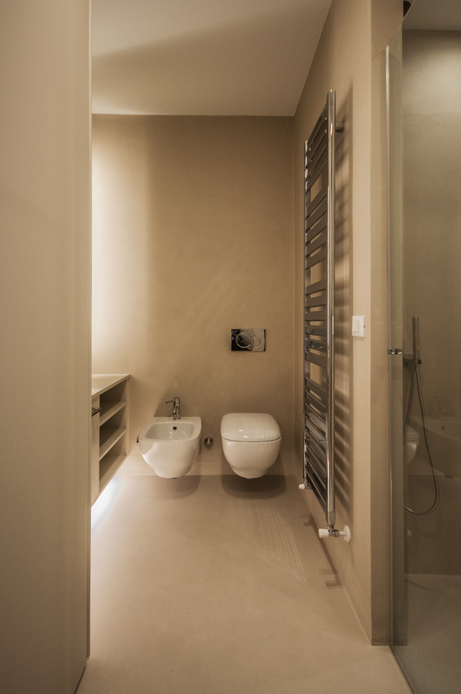 Kleines Modernes Duschbad mit hellen Holzschränken, bodengleicher Dusche, Wandtoilette, Spiegelfliesen, Betonboden, Aufsatzwaschbecken, beigem Boden und Falttür-Duschabtrennung in Mailand