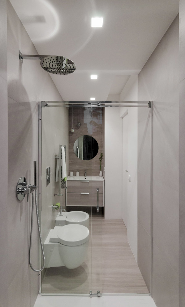 Exempel på ett litet modernt badrum med dusch, med släta luckor, skåp i ljust trä, grå kakel, porslinskakel, grå väggar, klinkergolv i porslin, ett integrerad handfat, bänkskiva i kvarts, grått golv, en kantlös dusch, dusch med skjutdörr och en bidé