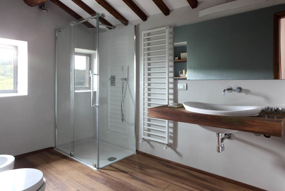 Aménagement d'une grande salle d'eau contemporaine avec une douche d'angle, un mur gris, un sol en bois brun, un lavabo posé et un plan de toilette en bois.
