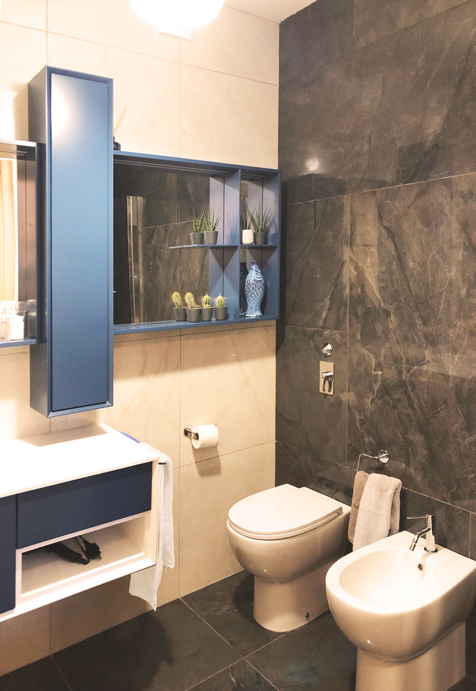 Inspiration pour une salle de bain design de taille moyenne avec une baignoire indépendante, un bidet, un carrelage gris, un mur blanc, un plan de toilette en surface solide, un sol gris, un plan de toilette blanc, un placard à porte plane, des portes de placard bleues, du carrelage en marbre, un sol en marbre, un lavabo intégré et une cabine de douche à porte battante.