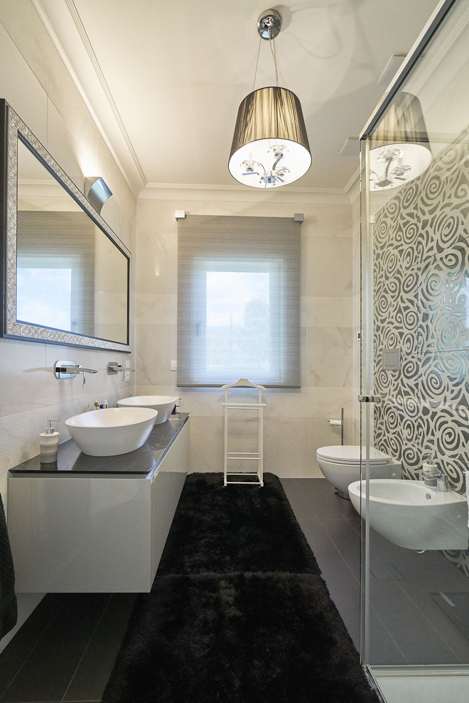 Modernes Duschbad mit weißen Schränken, grauer Waschtischplatte, flächenbündigen Schrankfronten, Wandtoilette, beiger Wandfarbe, Aufsatzwaschbecken und grauem Boden
