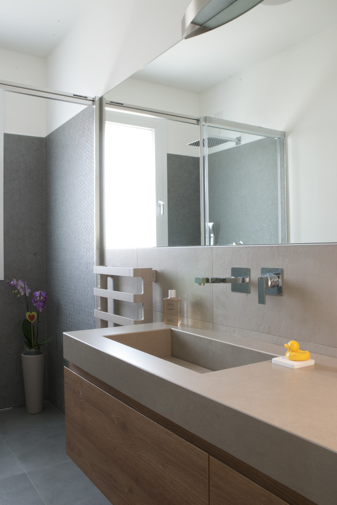 Источник вдохновения для домашнего уюта: ванная комната среднего размера в современном стиле с душем без бортиков, раздельным унитазом, коричневой плиткой, керамогранитной плиткой, коричневыми стенами, полом из керамогранита, душевой кабиной, монолитной раковиной, серым полом, душем с раздвижными дверями и коричневой столешницей