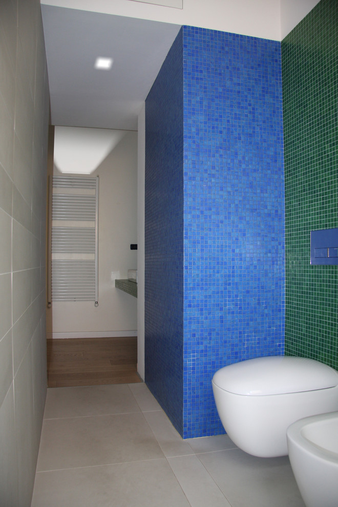 Idéer för ett mellanstort modernt en-suite badrum, med en kantlös dusch, en vägghängd toalettstol, grön kakel, mosaik, gröna väggar, klinkergolv i keramik, ett fristående handfat och kaklad bänkskiva