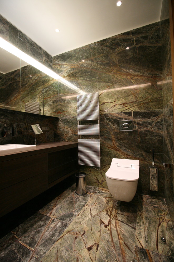 Foto de cuarto de baño actual de tamaño medio con armarios con paneles lisos, puertas de armario de madera oscura, ducha a ras de suelo, baldosas y/o azulejos de mármol y aseo y ducha