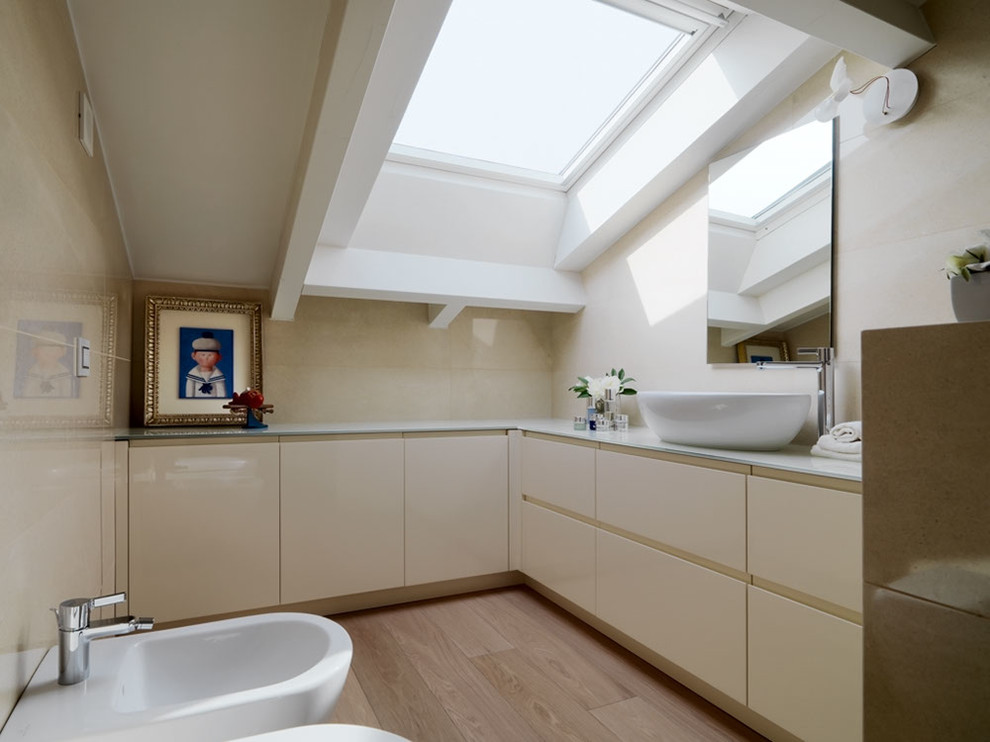 Ejemplo de cuarto de baño contemporáneo con armarios con paneles lisos, bidé, lavabo sobreencimera, puertas de armario beige, paredes beige y suelo de madera clara
