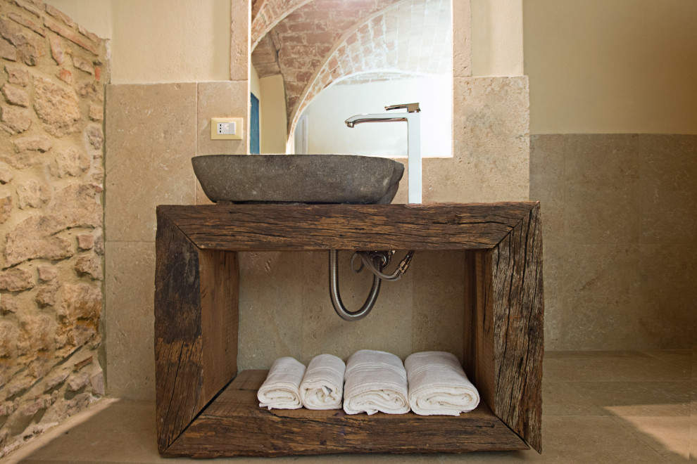 Aménagement d'une salle de bain éclectique en bois foncé de taille moyenne avec un placard sans porte, une baignoire d'angle, une douche ouverte, un mur beige, un sol en travertin, une vasque, un plan de toilette en bois et un sol beige.