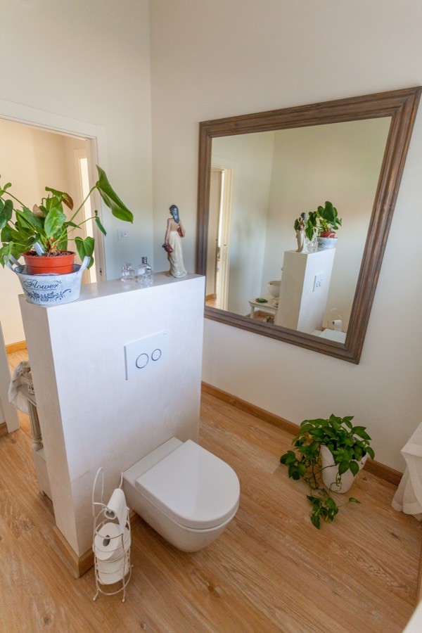 Foto de cuarto de baño principal campestre grande con bañera exenta, paredes beige, suelo de madera en tonos medios y suelo marrón