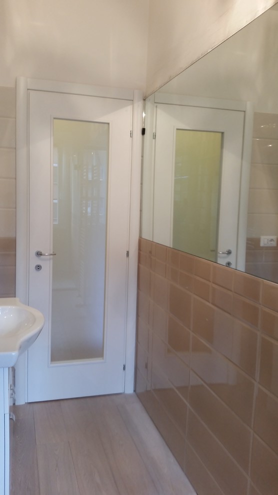 Ispirazione per una piccola stanza da bagno con doccia tradizionale con ante bianche, piastrelle rosa, pareti bianche, parquet chiaro e lavabo integrato