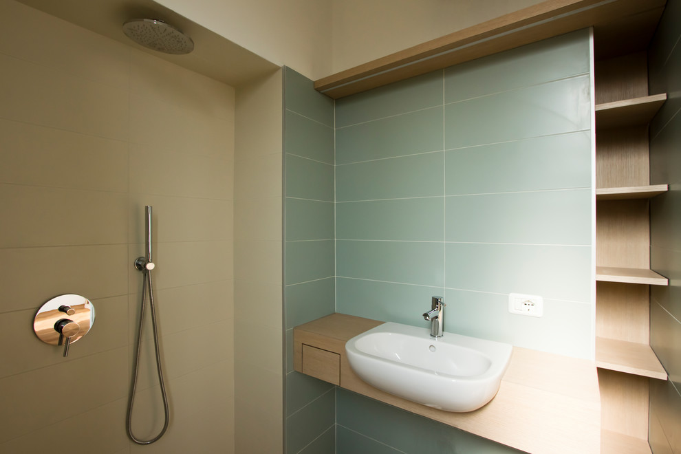 Idéer för att renovera ett litet skandinaviskt brun brunt badrum med dusch, med öppna hyllor, skåp i ljust trä, en kantlös dusch, en vägghängd toalettstol, grön kakel, porslinskakel, gröna väggar, klinkergolv i porslin, ett integrerad handfat, träbänkskiva, grått golv och med dusch som är öppen