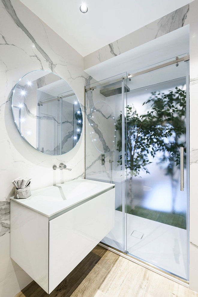 Immagine di una stanza da bagno padronale minimal di medie dimensioni con doccia alcova, piastrelle bianche, piastrelle di marmo, pareti bianche, pavimento in gres porcellanato, lavabo sospeso, pavimento marrone e porta doccia scorrevole