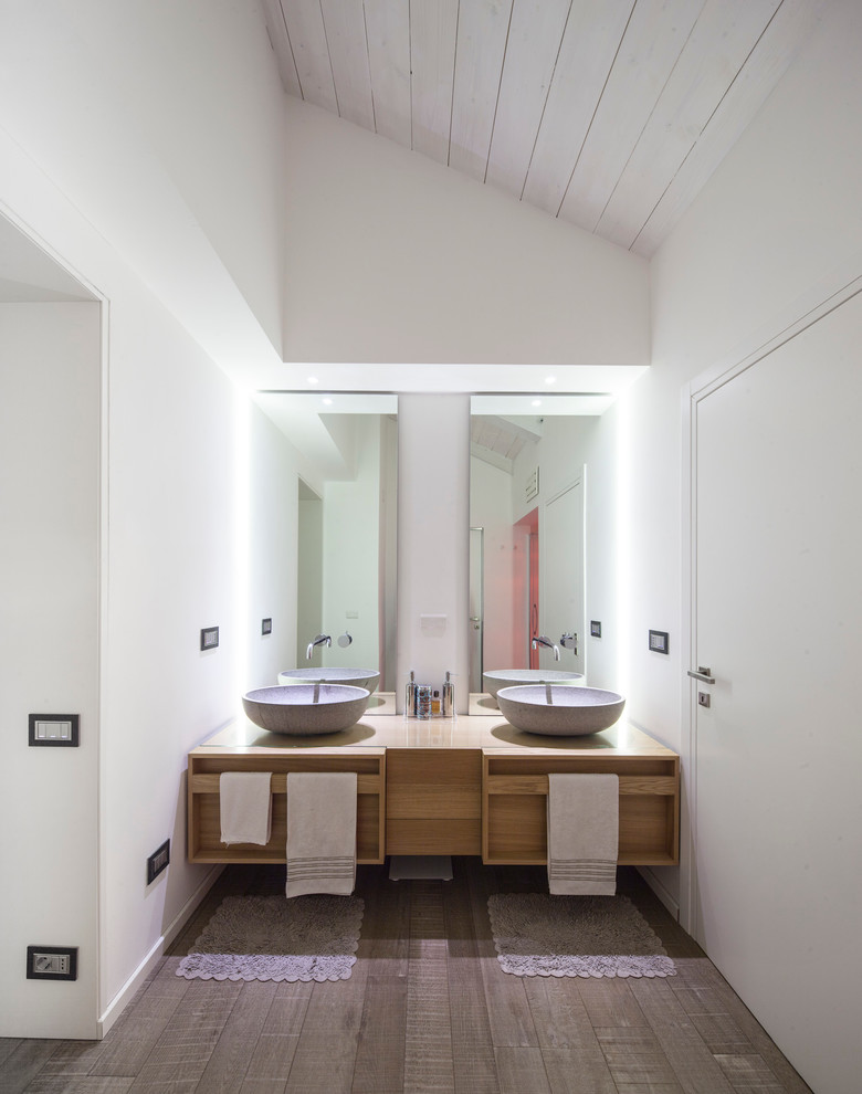 Идея дизайна: ванная комната в современном стиле с плоскими фасадами, светлыми деревянными фасадами, белыми стенами, настольной раковиной, столешницей из дерева, темным паркетным полом и коричневой столешницей