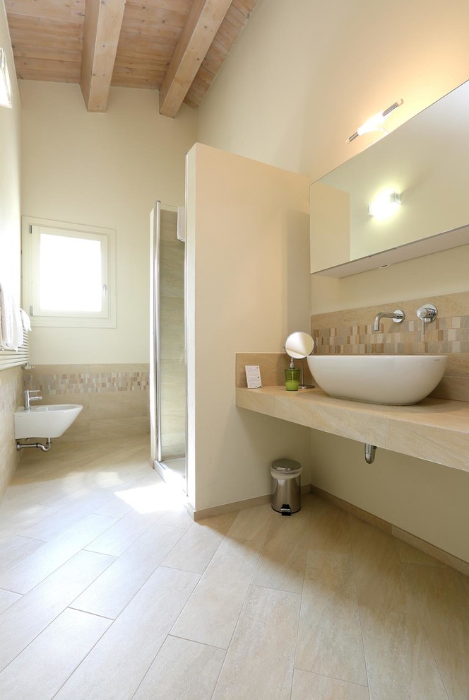 Cette image montre une salle de bain design de taille moyenne avec WC suspendus, un carrelage beige, des carreaux de porcelaine, un mur blanc, un sol en carrelage de porcelaine, une vasque, un plan de toilette en carrelage, un sol beige, une cabine de douche à porte battante et un plan de toilette beige.