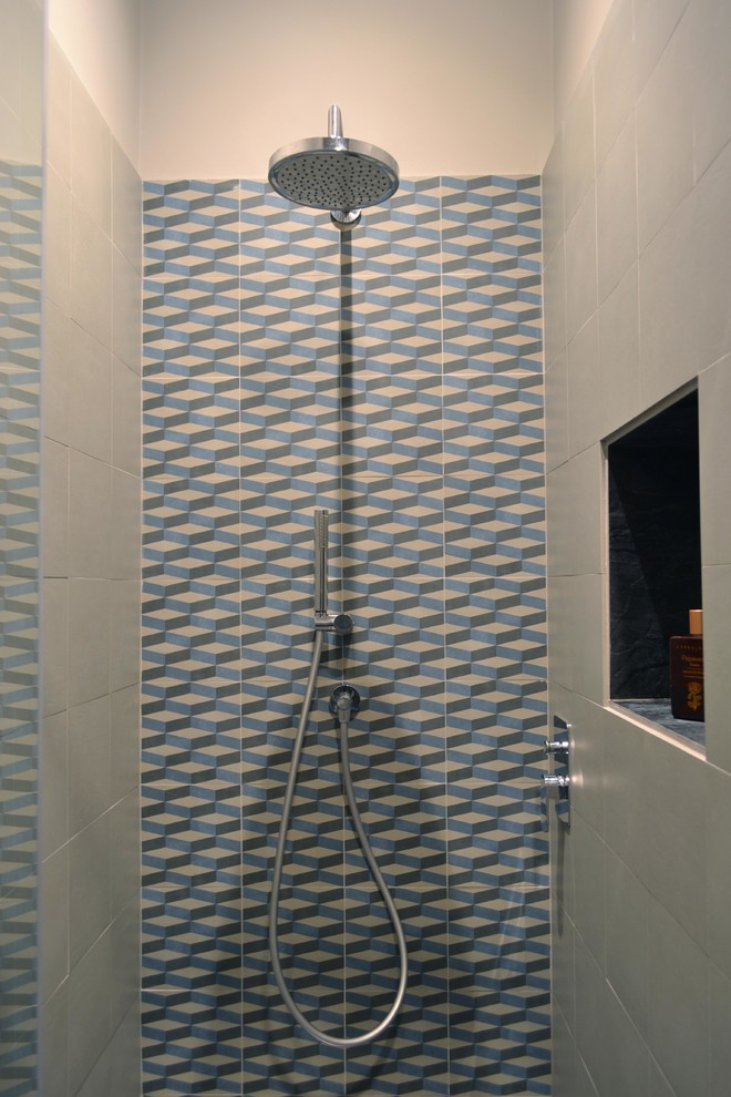 Small trendy 3/4 multicolored tile and cement tile porcelain tile and gray floor corner shower photo in Milan with flat-panel cabinets, light wood cabinets, a two-piece toilet, gray walls, an integrated sink, solid surface countertops, a hinged shower door and white countertops