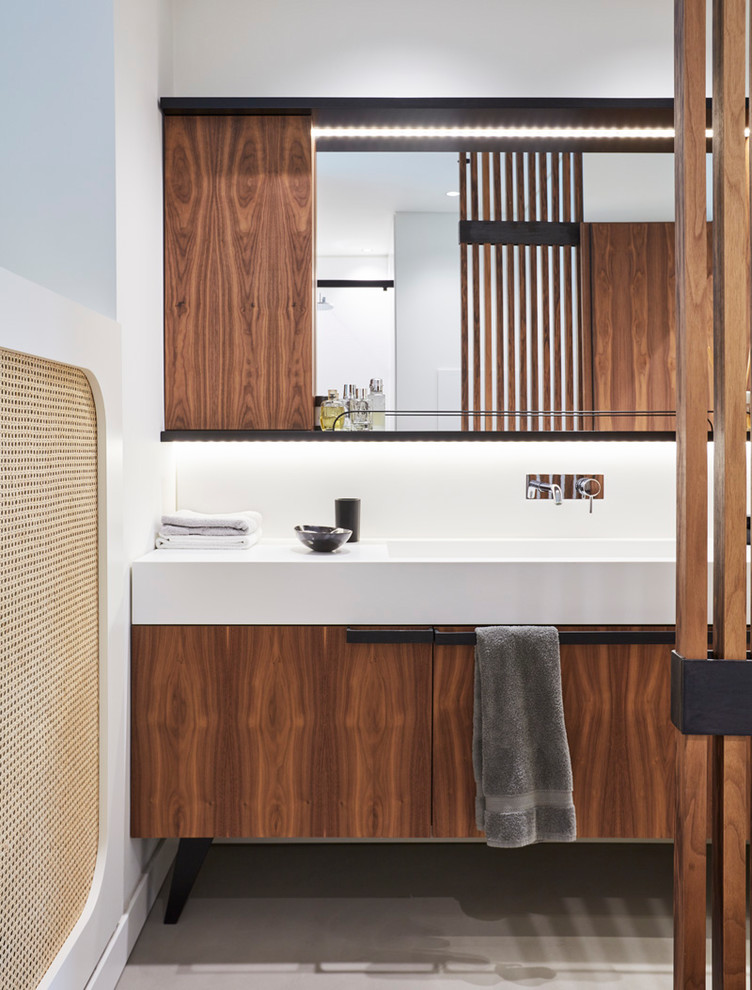 Modernes Badezimmer mit flächenbündigen Schrankfronten, braunen Schränken, weißen Fliesen, weißer Wandfarbe, Waschtischkonsole und beigem Boden in Turin