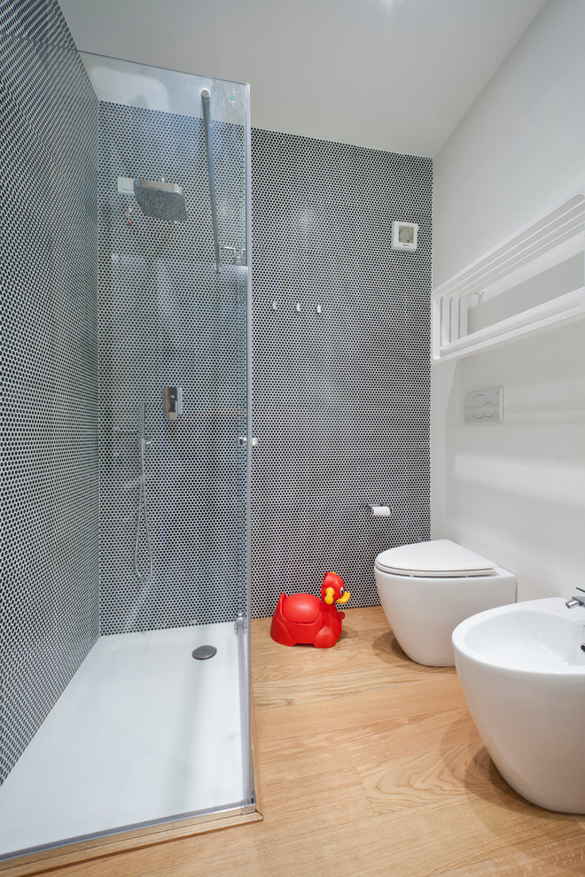Esempio di una piccola stanza da bagno con doccia minimal con doccia ad angolo, bidè, pistrelle in bianco e nero, piastrelle in ceramica, pareti bianche e parquet chiaro