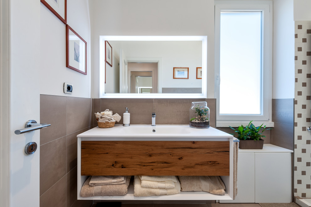 Immagine di una stanza da bagno contemporanea con ante lisce, ante in legno scuro, piastrelle grigie, pareti bianche, lavabo integrato, top bianco, un lavabo e mobile bagno sospeso
