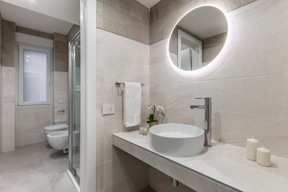 Example of a mid-sized trendy 3/4 porcelain tile and beige tile porcelain tile and gray floor corner shower design in Milan with a wall-mount toilet, beige walls, a vessel sink, tile countertops, a floating vanity, a hinged shower door and beige countertops