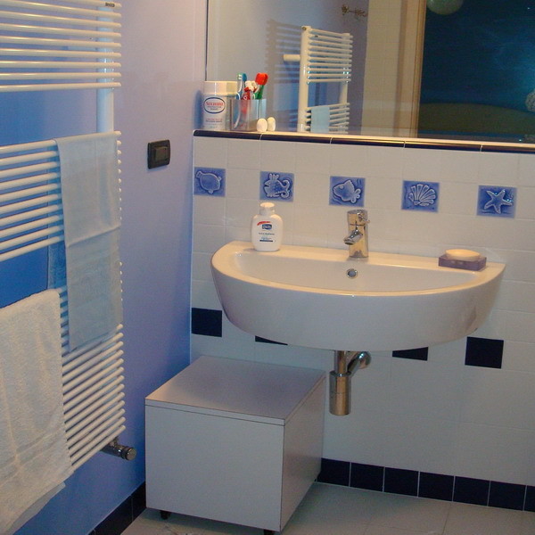 Inspiration for a beach style bathroom in Turin with a corner shower, blue tiles, ceramic flooring and a console sink.