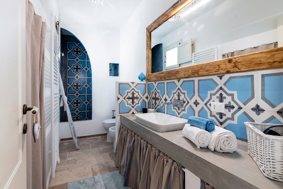 Mediterranes Duschbad mit offenen Schränken, Duschnische, Toilette mit Aufsatzspülkasten, blauen Fliesen, weißer Wandfarbe, Einbauwaschbecken, Beton-Waschbecken/Waschtisch, beigem Boden, offener Dusche und grauer Waschtischplatte in Sonstige