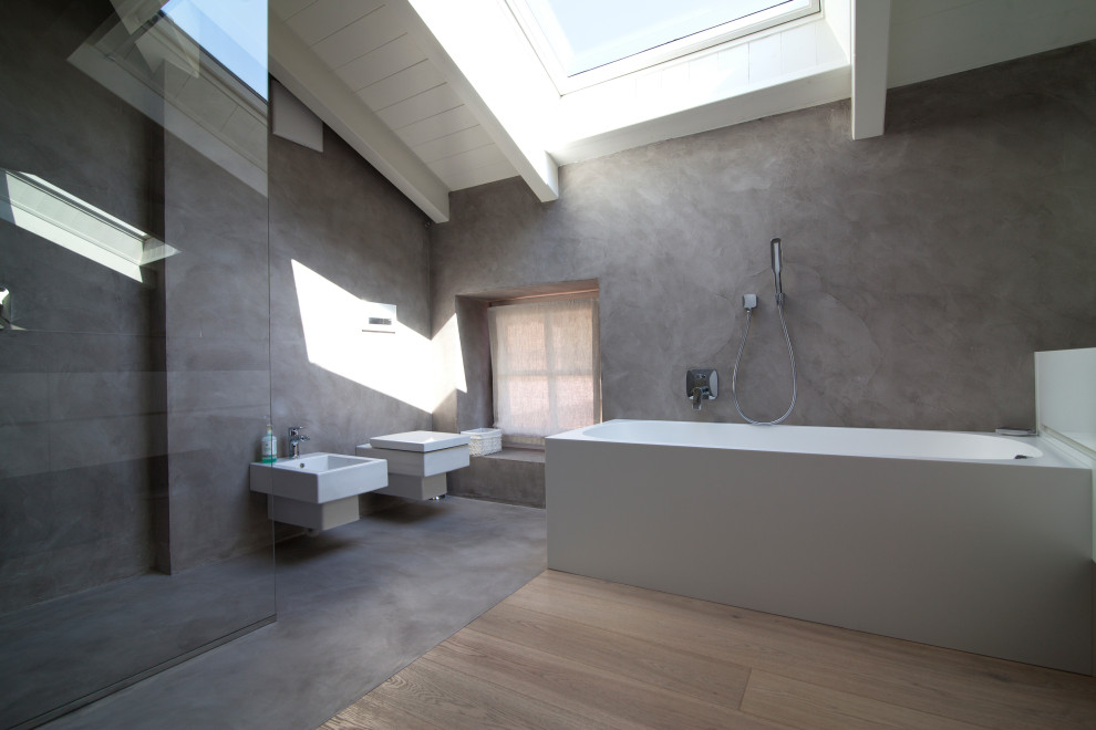 Inspiration for a medium sized modern ensuite bathroom in Other with flat-panel cabinets, white cabinets, an alcove bath, a built-in shower, a wall mounted toilet, grey walls, a wall-mounted sink, solid surface worktops, an open shower, white worktops, a single sink, a freestanding vanity unit and exposed beams.
