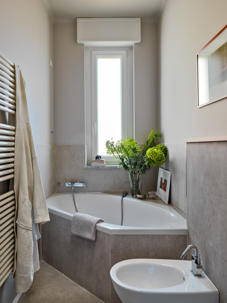 Photo of a small modern ensuite bathroom in Milan with flat-panel cabinets, a built-in bath, beige tiles, porcelain tiles, beige walls, porcelain flooring, a trough sink, beige floors and a bidet.