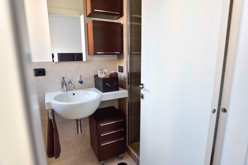 Exempel på ett litet modernt badrum med dusch, med skåp i mörkt trä, en dusch i en alkov, en toalettstol med separat cisternkåpa, beige kakel, porslinskakel, klinkergolv i porslin, ett väggmonterat handfat, vita väggar, släta luckor och beiget golv