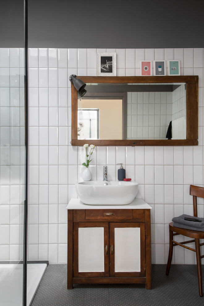 Industriell inredning av ett mellanstort vit vitt badrum med dusch, med skåp i shakerstil, skåp i mörkt trä, vit kakel, tunnelbanekakel, grå väggar, klinkergolv i porslin, grått golv, med dusch som är öppen, en dusch i en alkov och ett fristående handfat