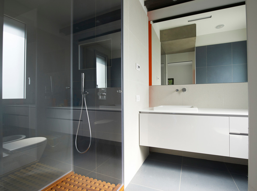 Modelo de cuarto de baño moderno con armarios con paneles lisos, puertas de armario blancas, aseo y ducha y lavabo encastrado
