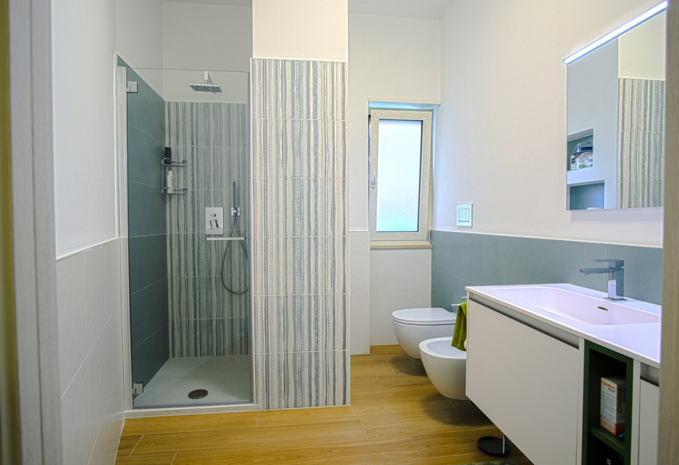 Источник вдохновения для домашнего уюта: большая ванная комната в стиле модернизм с плоскими фасадами, белыми фасадами, душем в нише, зеленой плиткой, керамогранитной плиткой, белыми стенами, полом из керамогранита, монолитной раковиной, мраморной столешницей, коричневым полом, душем с распашными дверями, белой столешницей, тумбой под одну раковину, подвесной тумбой и кирпичными стенами