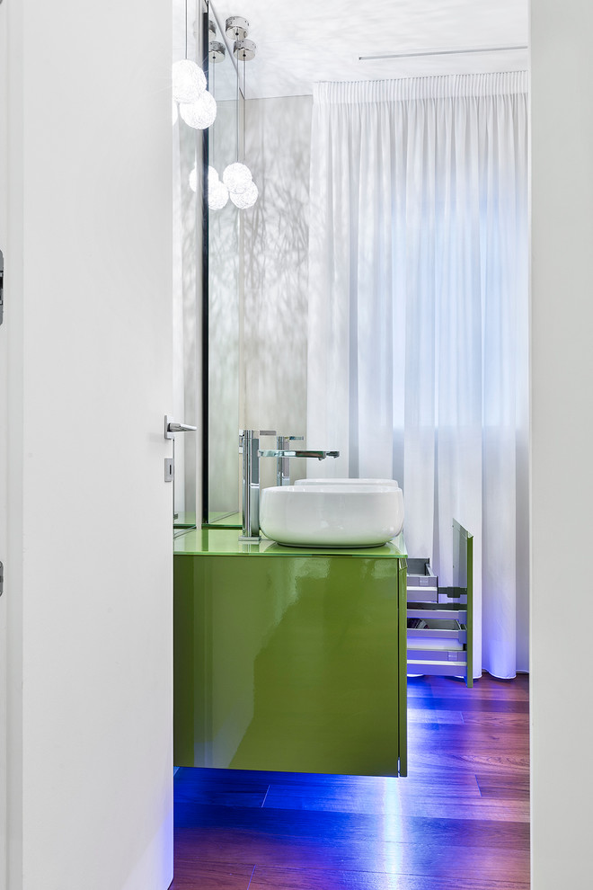 Inspiration pour une salle de bain design de taille moyenne avec un placard à porte plane, des portes de placards vertess, WC séparés, un carrelage beige, mosaïque, un mur beige, un sol en bois brun, une vasque et un plan de toilette en verre.