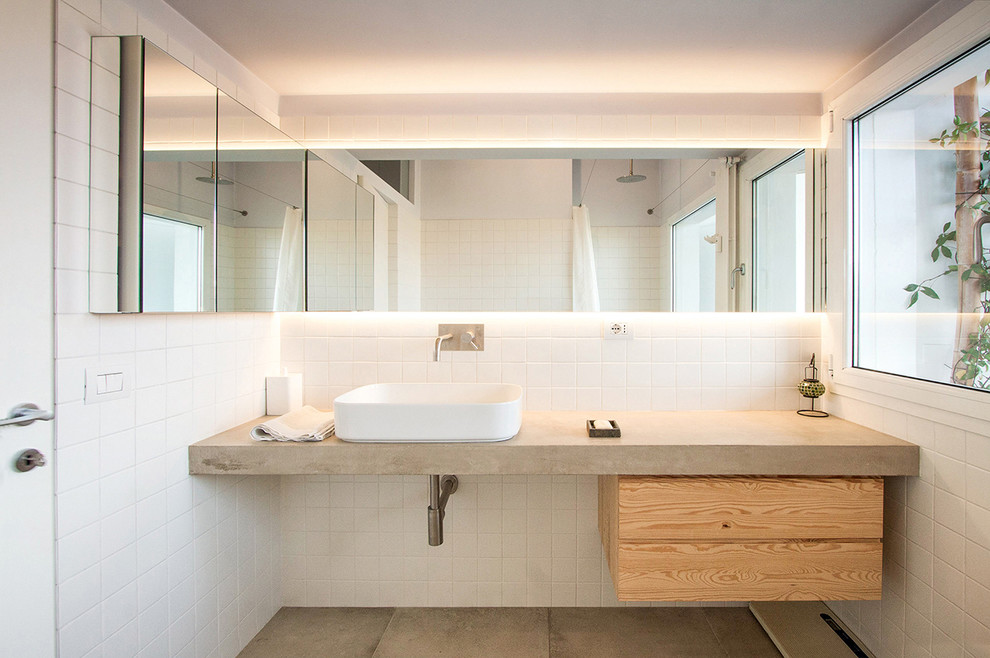 Idéer för att renovera ett mellanstort industriellt en-suite badrum, med släta luckor, ett platsbyggt badkar, en dusch/badkar-kombination, en vägghängd toalettstol, vit kakel, keramikplattor, vita väggar, ett fristående handfat, bänkskiva i betong och dusch med duschdraperi