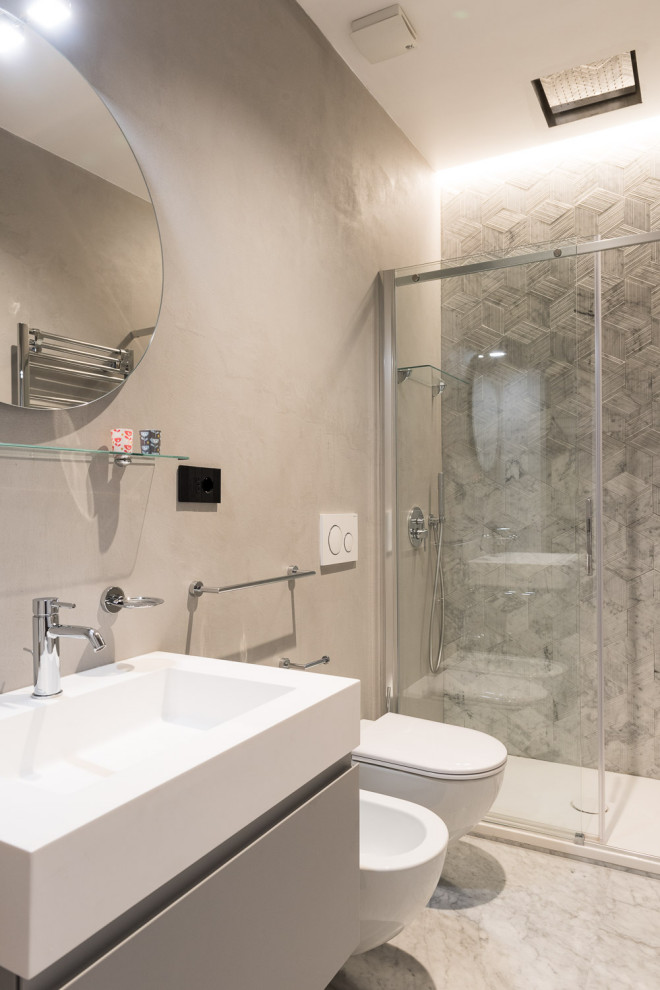 Exempel på ett mellanstort modernt vit vitt badrum med dusch, med släta luckor, grå skåp, en dusch i en alkov, en vägghängd toalettstol, grå kakel, ett integrerad handfat, grönt golv och dusch med gångjärnsdörr