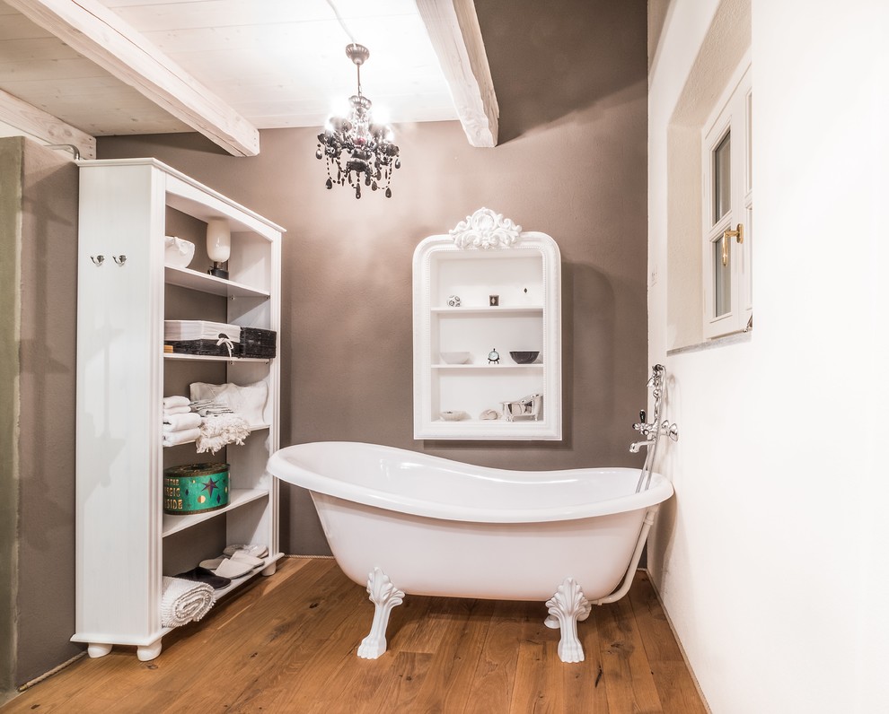 Exemple d'une salle de bain principale nature de taille moyenne avec des portes de placard blanches, une baignoire sur pieds, une douche à l'italienne, WC séparés, un mur multicolore, un sol en bois brun et une vasque.